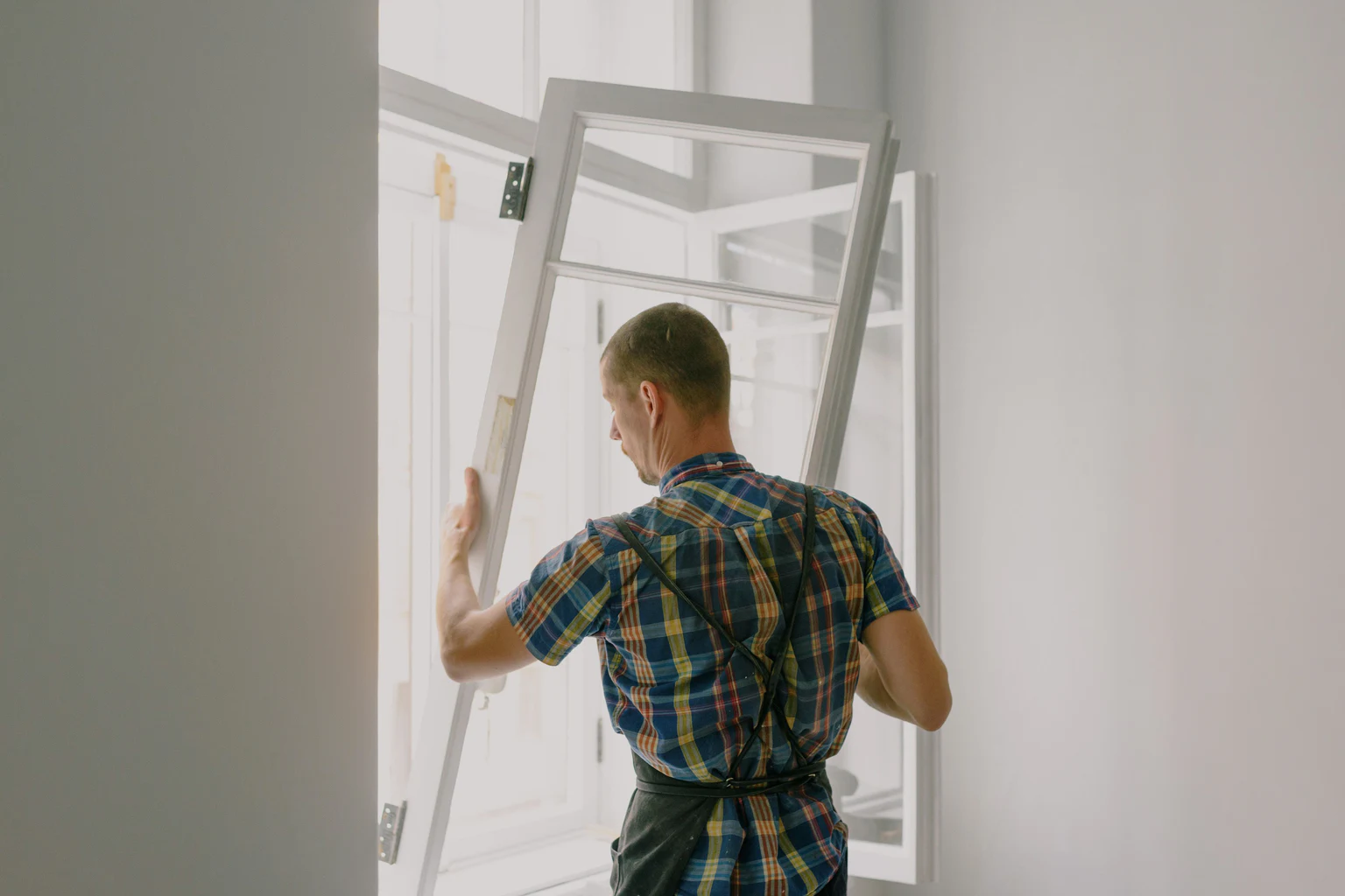 Professional installer handling a window unit inside a finished room