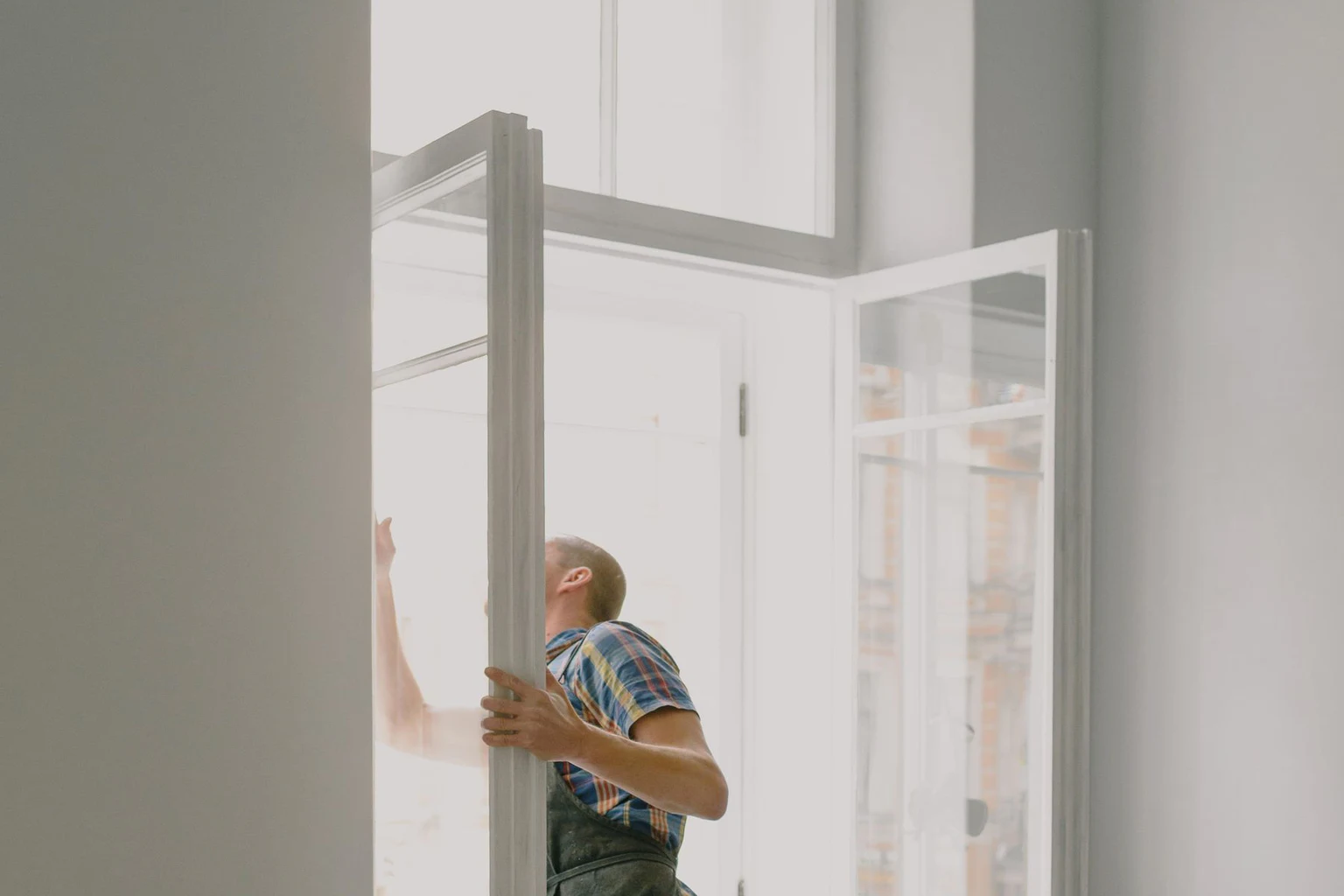 Professional installer positioning a window unit at a finished interior opening